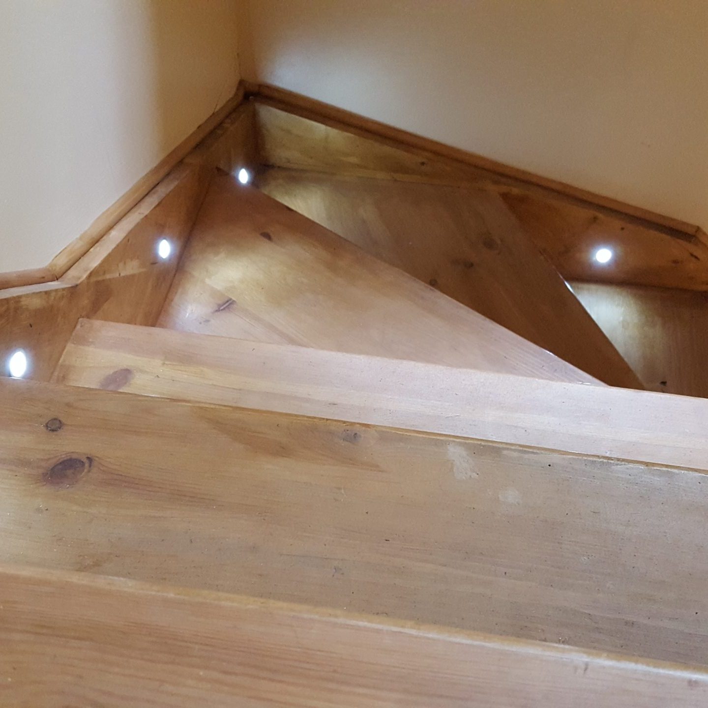 Wooden staircase with spot lights by steps