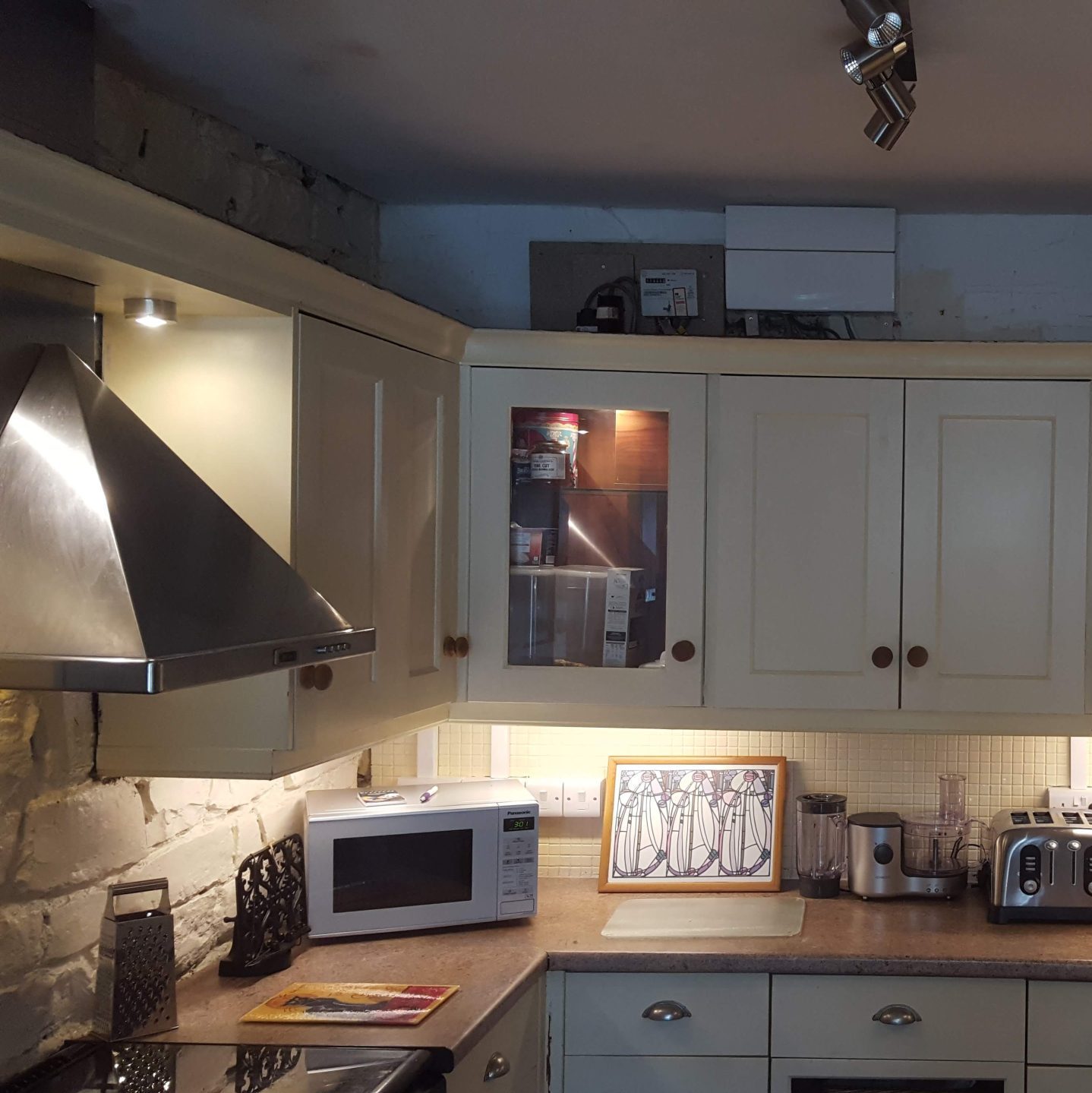 Kitchen lit up with spot lights and electrical appliances