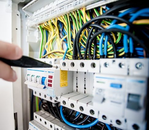 a hand holding a tool to a circuit board