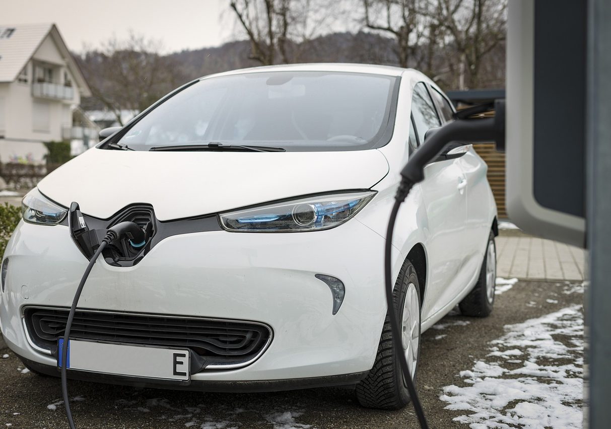 Electric vehicle being charged on driveway